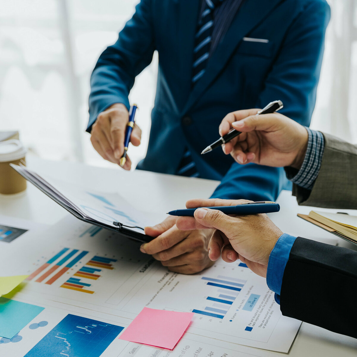 Business team discussing data on a clipboard