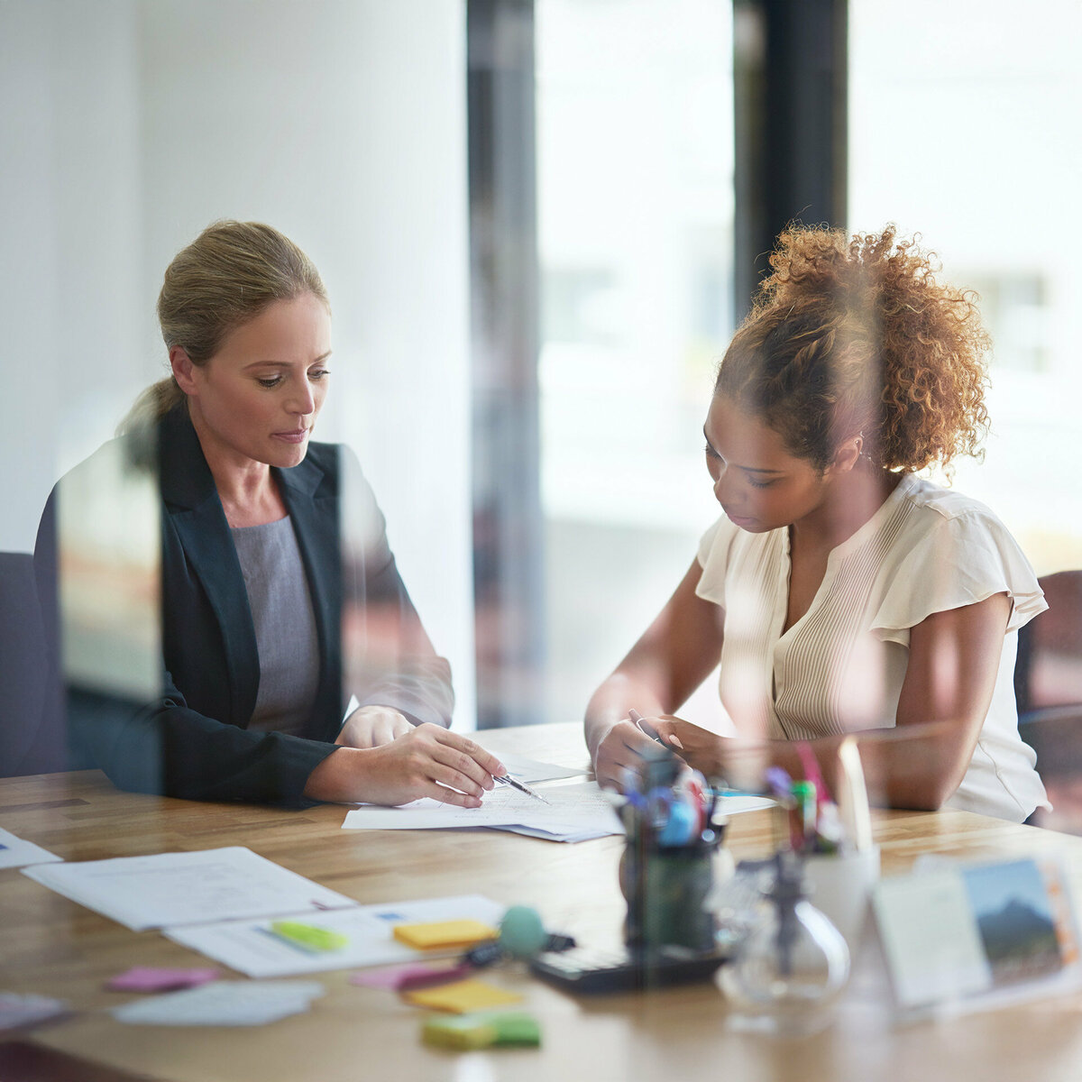 A business woman and client in a meeting room discussing a contract