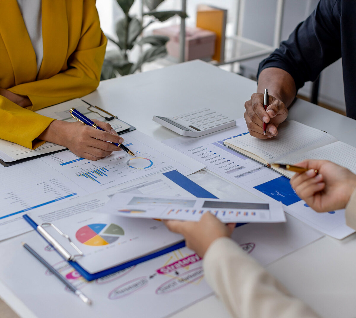 Three people sitting around a table evaluating data