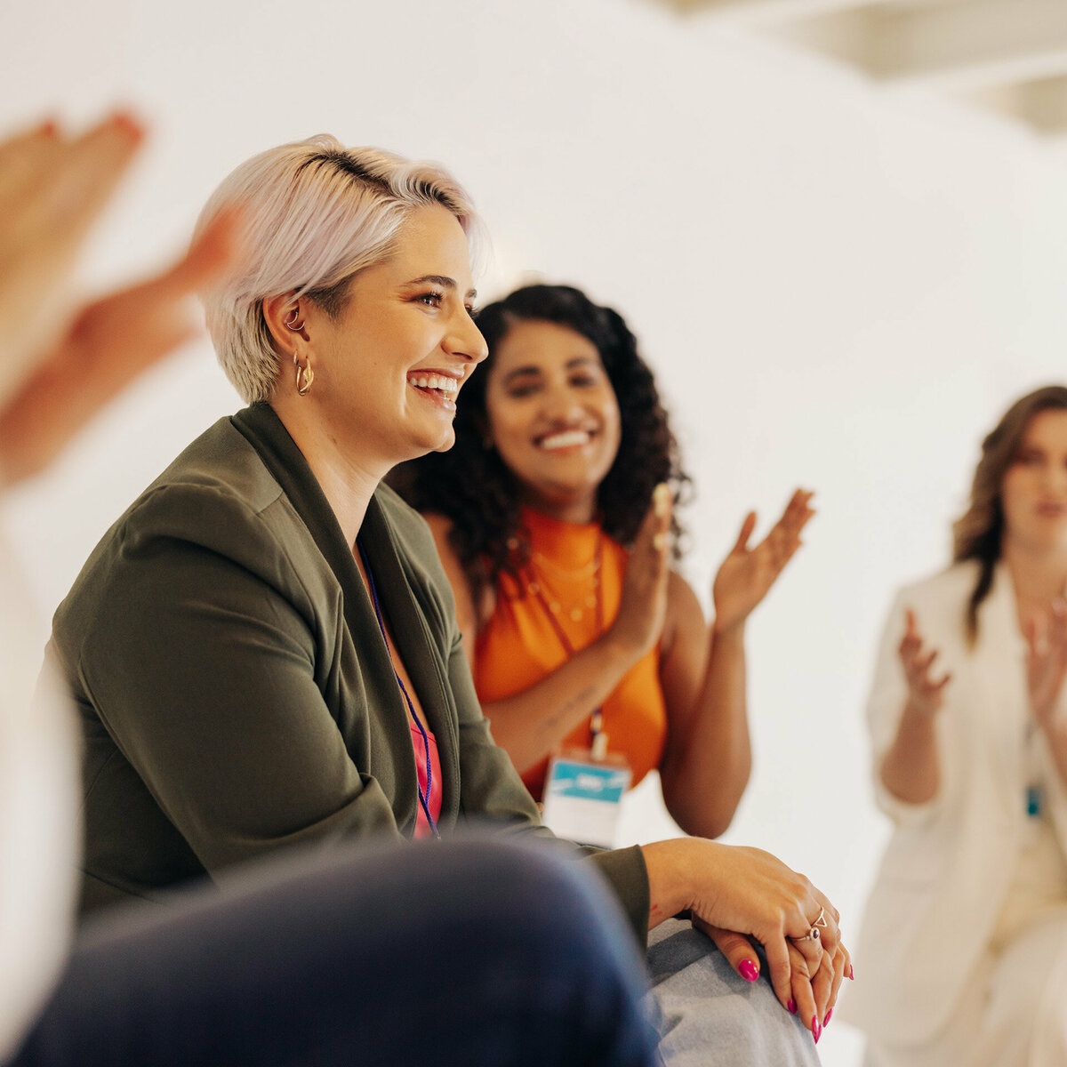 Smiling businesswomen applauding their colleague in an office